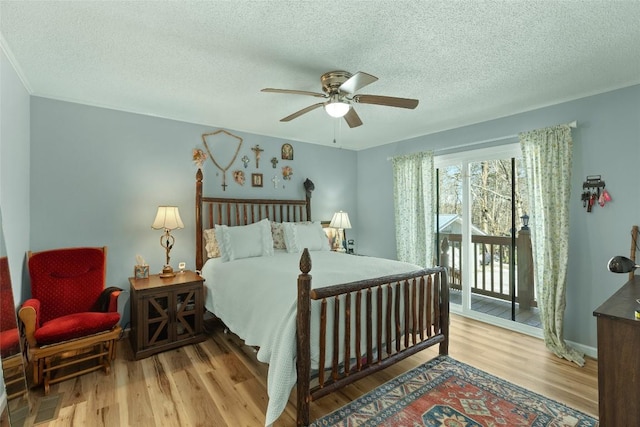 bedroom featuring light wood-type flooring, a textured ceiling, access to exterior, and ceiling fan