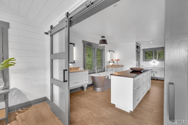 kitchen with white cabinetry, a wealth of natural light, a center island, and a barn door