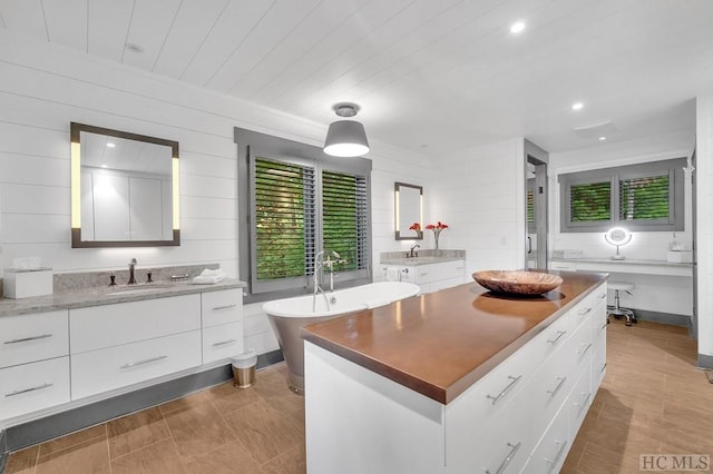 kitchen with a kitchen island, sink, and white cabinets