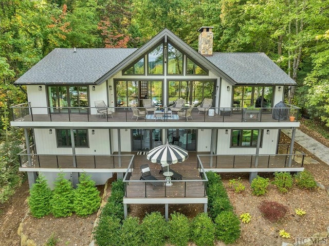 back of house featuring a balcony and outdoor lounge area