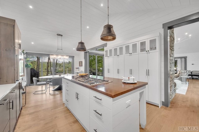 kitchen with stainless steel gas stovetop, a large island, hanging light fixtures, and white cabinets