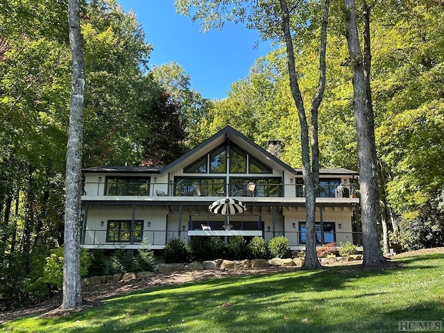 back of house featuring a yard and a balcony