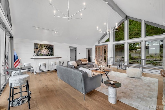 living room featuring beamed ceiling, a chandelier, high vaulted ceiling, and light wood-type flooring