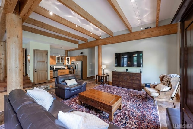 living room featuring beam ceiling, visible vents, and decorative columns