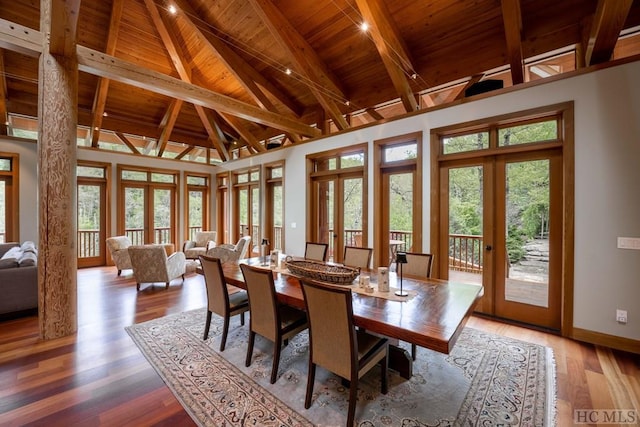 dining room featuring a healthy amount of sunlight, wood ceiling, wood finished floors, and french doors