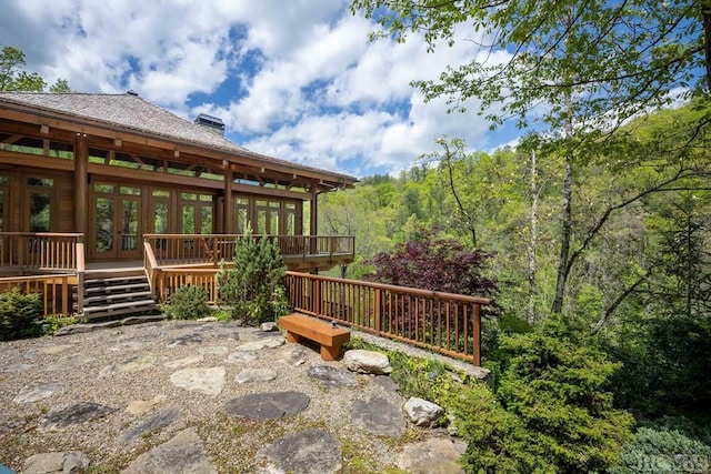 wooden deck featuring french doors and a wooded view