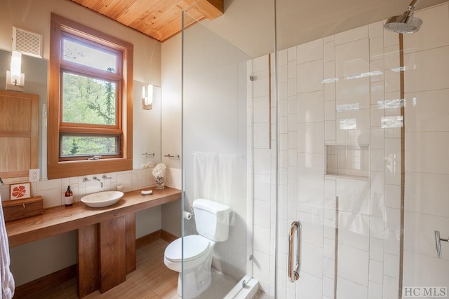 full bathroom featuring toilet, a stall shower, visible vents, and decorative backsplash