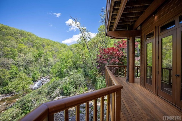 balcony with french doors and a wooded view