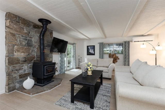 142 Wheatstone Dr, Glenville, NC 28736 - living room featuring a wall mounted AC, a wood stove, beam ceiling, and wood finished floors
