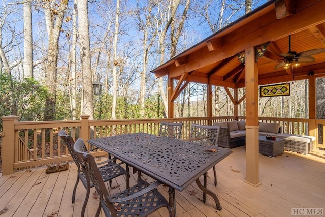 wooden deck with a gazebo, an outdoor hangout area, and ceiling fan