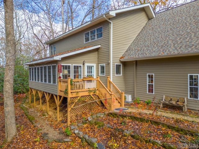 rear view of property with a wooden deck and a sunroom