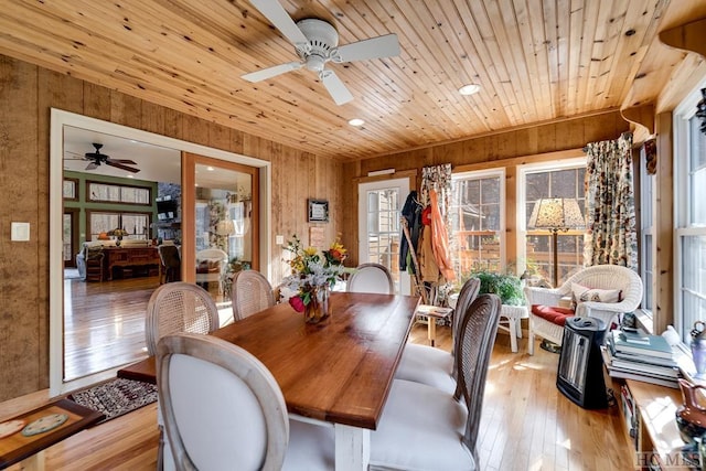 dining area featuring wooden walls, light hardwood / wood-style flooring, and wooden ceiling