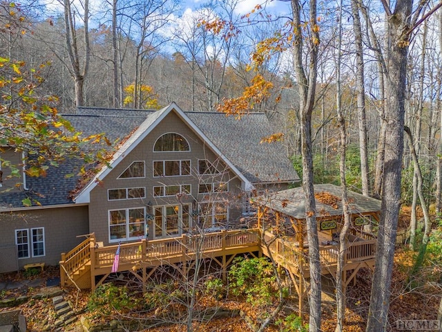 back of property with a wooden deck and a gazebo