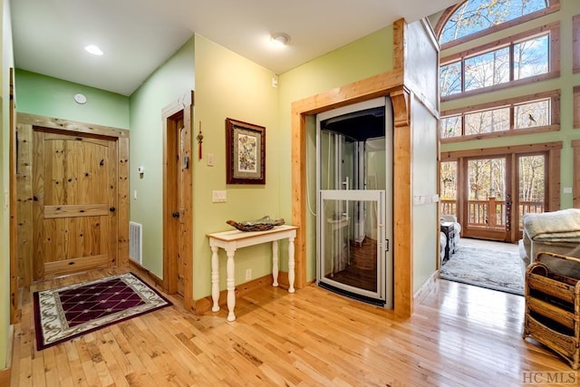 doorway with french doors and light hardwood / wood-style flooring