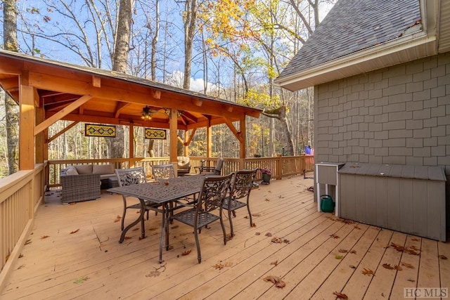 wooden terrace featuring an outdoor hangout area, ceiling fan, and a gazebo