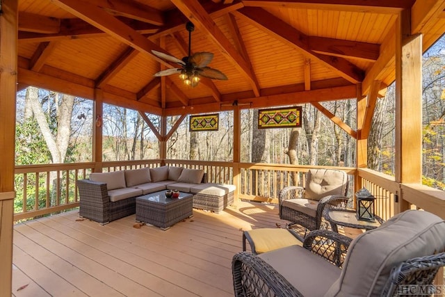 sunroom / solarium with ceiling fan, vaulted ceiling with beams, and wood ceiling