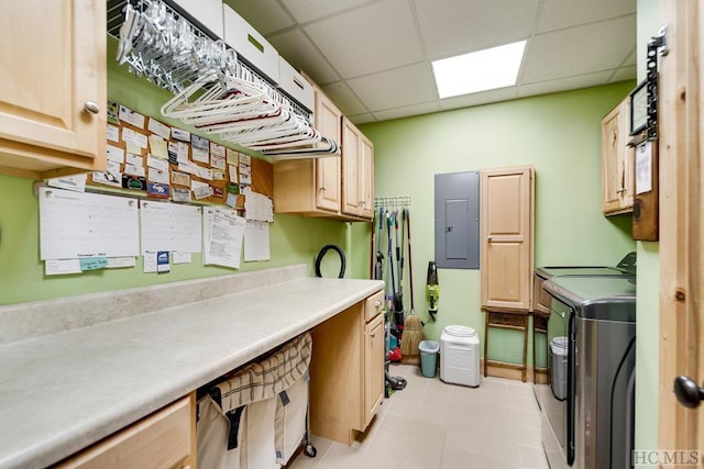 clothes washing area with electric panel, washing machine and dryer, and cabinets