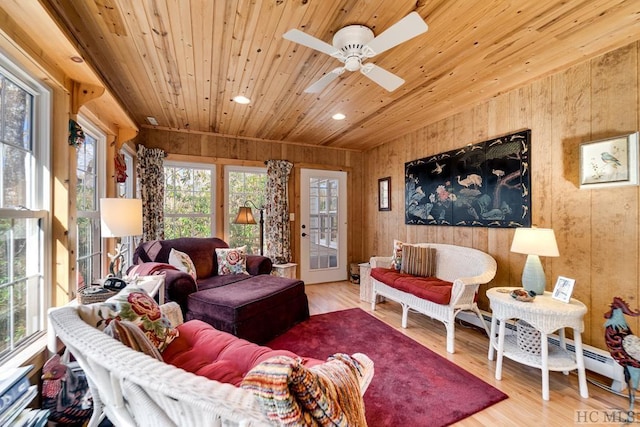 living room with ceiling fan, light hardwood / wood-style floors, wood ceiling, and wood walls