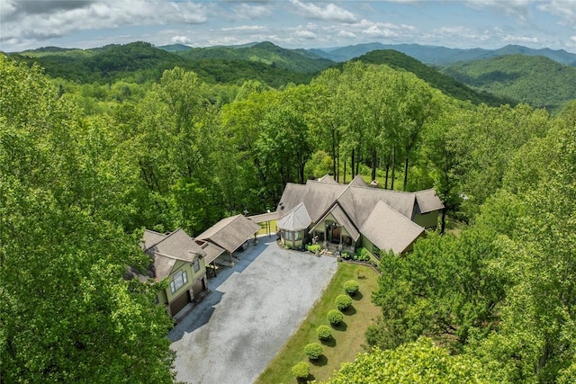 aerial view of property and surrounding area with a heavily wooded area and a mountainous background