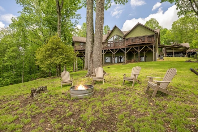 view of grassy yard featuring a fire pit and a deck