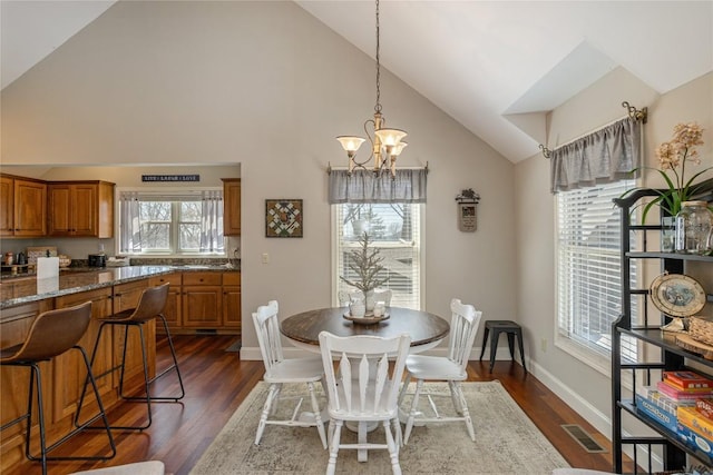 dining area with high vaulted ceiling, a chandelier, dark wood-type flooring, and baseboards