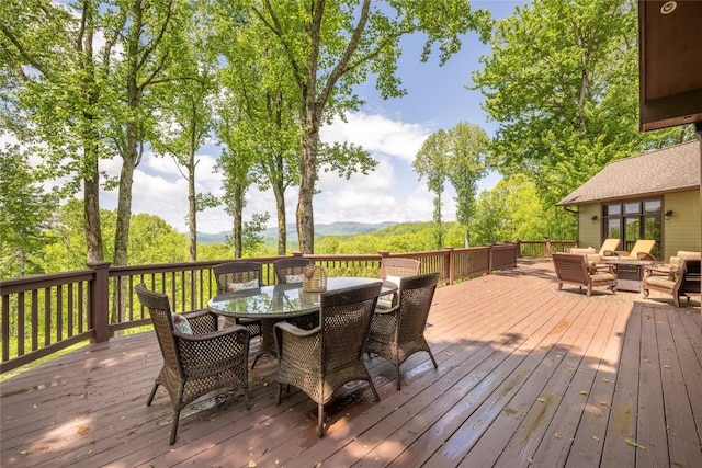 deck featuring an outdoor hangout area, outdoor dining space, and a mountain view