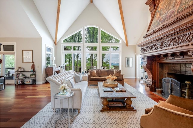 living area with a fireplace, wood finished floors, baseboards, and high vaulted ceiling