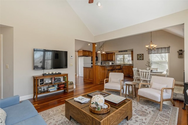 living room featuring a chandelier, light wood-style floors, recessed lighting, baseboards, and high vaulted ceiling