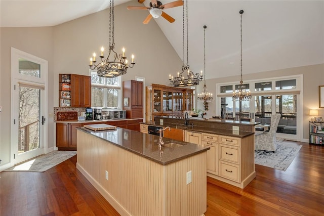 kitchen with a chandelier, a spacious island, high vaulted ceiling, and dark wood-type flooring