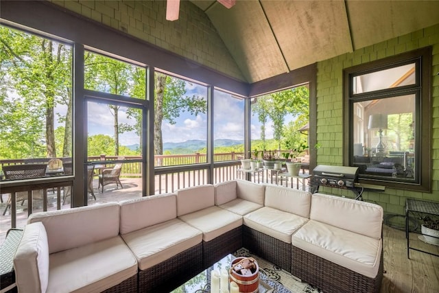 sunroom with an outdoor hangout area, vaulted ceiling, ceiling fan, and healthy amount of natural light