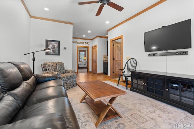 living room with ceiling fan, ornamental molding, and light hardwood / wood-style flooring