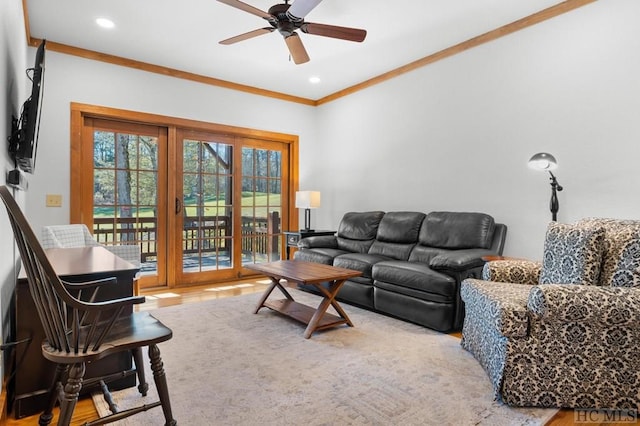 living room with ceiling fan, crown molding, and light hardwood / wood-style flooring