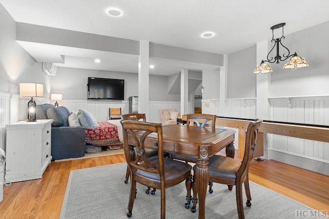 dining space featuring light hardwood / wood-style floors and a wall mounted air conditioner