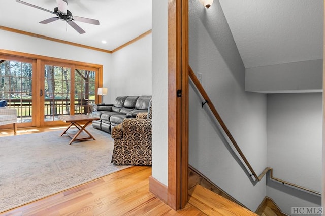 living room featuring ceiling fan, lofted ceiling, crown molding, and light hardwood / wood-style floors