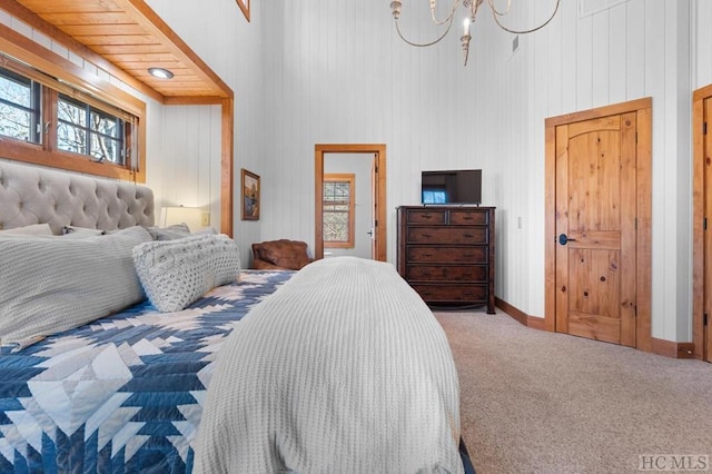 carpeted bedroom with an inviting chandelier and a high ceiling