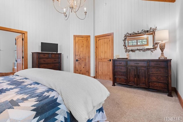 bedroom with light carpet, a towering ceiling, a notable chandelier, and two closets