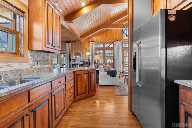 kitchen with light stone countertops, light hardwood / wood-style floors, wood ceiling, lofted ceiling with beams, and stainless steel fridge with ice dispenser