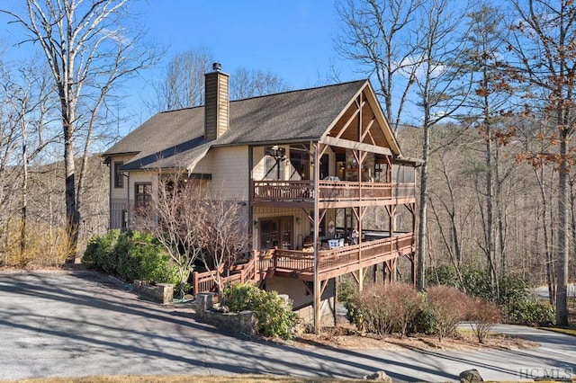 exterior space featuring a wooden deck and a balcony