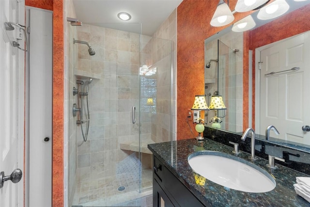 bathroom featuring vanity and a shower with door