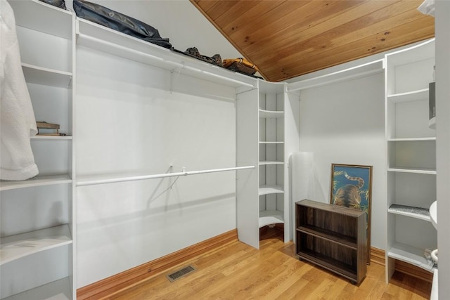 walk in closet with lofted ceiling and light hardwood / wood-style floors