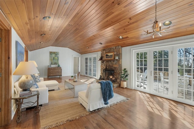 living room featuring french doors, lofted ceiling, wooden ceiling, a fireplace, and hardwood / wood-style floors