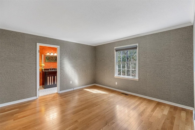 spare room featuring hardwood / wood-style floors and a textured ceiling