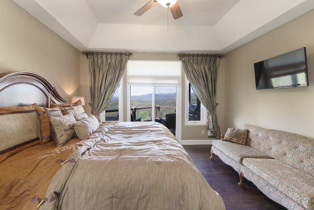 129 Skyline Park Dr, Franklin, NC 28734 - bedroom with dark wood-type flooring, a tray ceiling, a ceiling fan, and baseboards