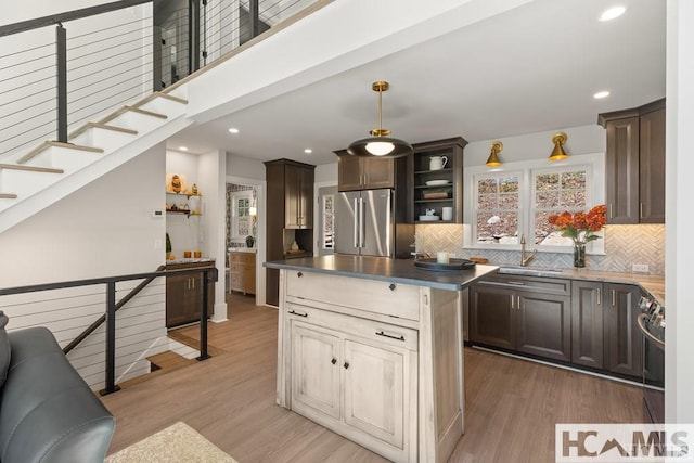 kitchen featuring appliances with stainless steel finishes, open shelves, a sink, light wood-type flooring, and recessed lighting