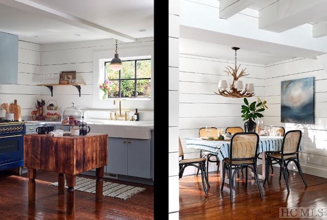 kitchen featuring pendant lighting, dark hardwood / wood-style flooring, gas stove, and beam ceiling