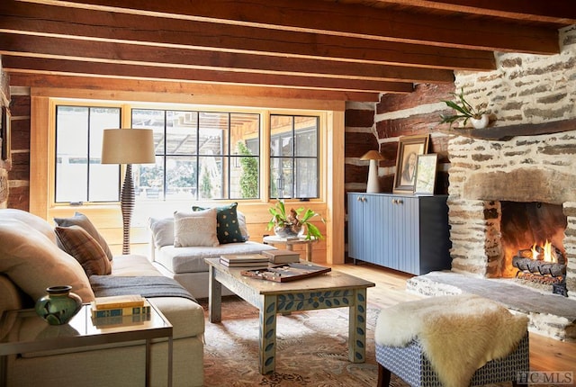 living room featuring a fireplace, beamed ceiling, and wood-type flooring