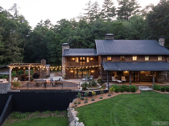 rear view of house featuring a yard, a patio, and an outdoor hangout area