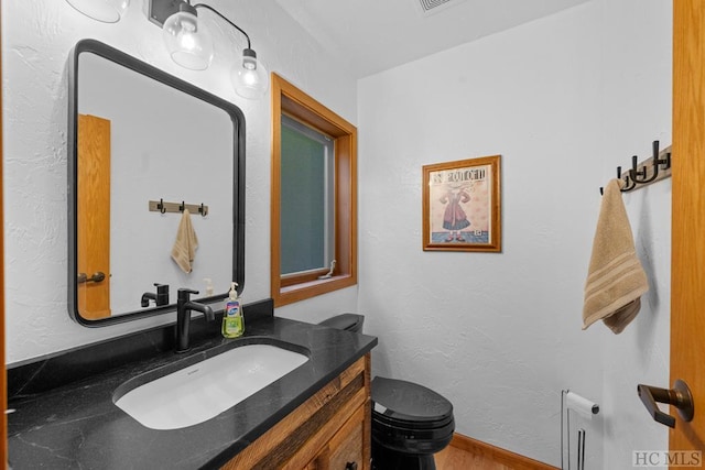 bathroom featuring vanity and toilet