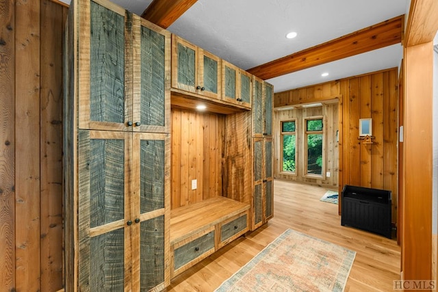 mudroom featuring beamed ceiling, hardwood / wood-style flooring, and wood walls