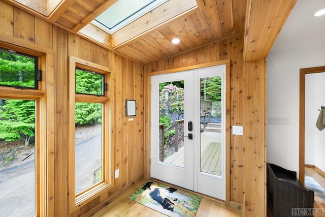 doorway to outside with french doors, a healthy amount of sunlight, a skylight, and light hardwood / wood-style flooring